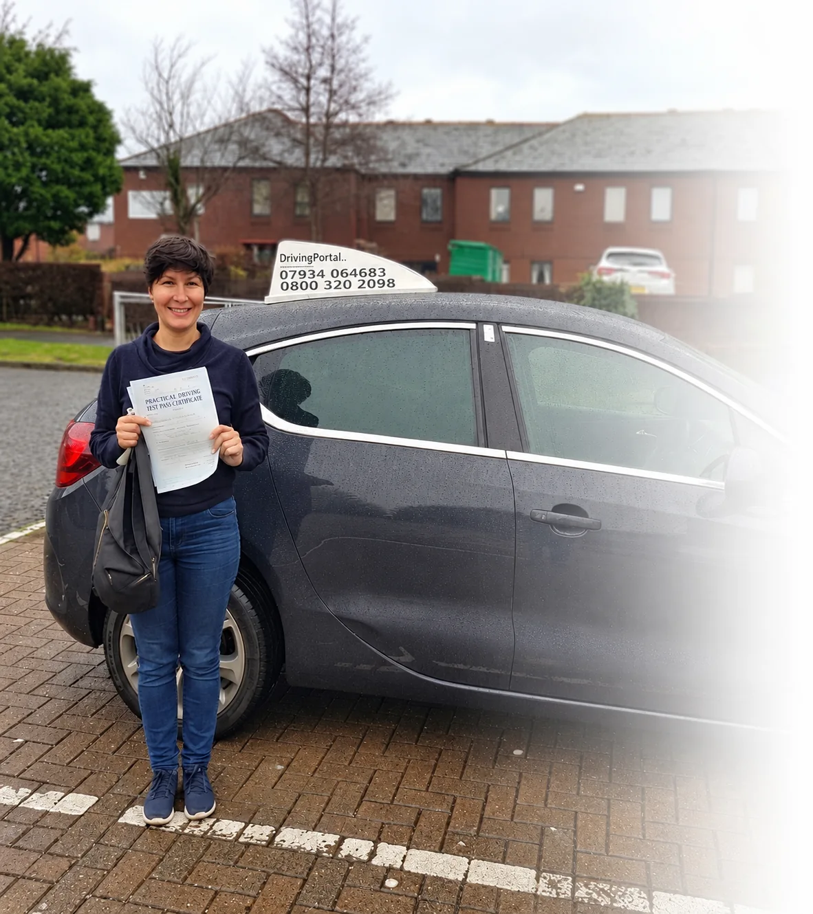 Smiling certificate holder beside a Driving Portal learner car